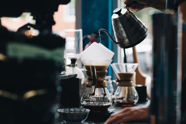 Barista pouring water over coffee using a Chemex