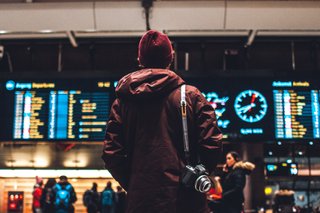 Man looking at the departures board at Oslo central station