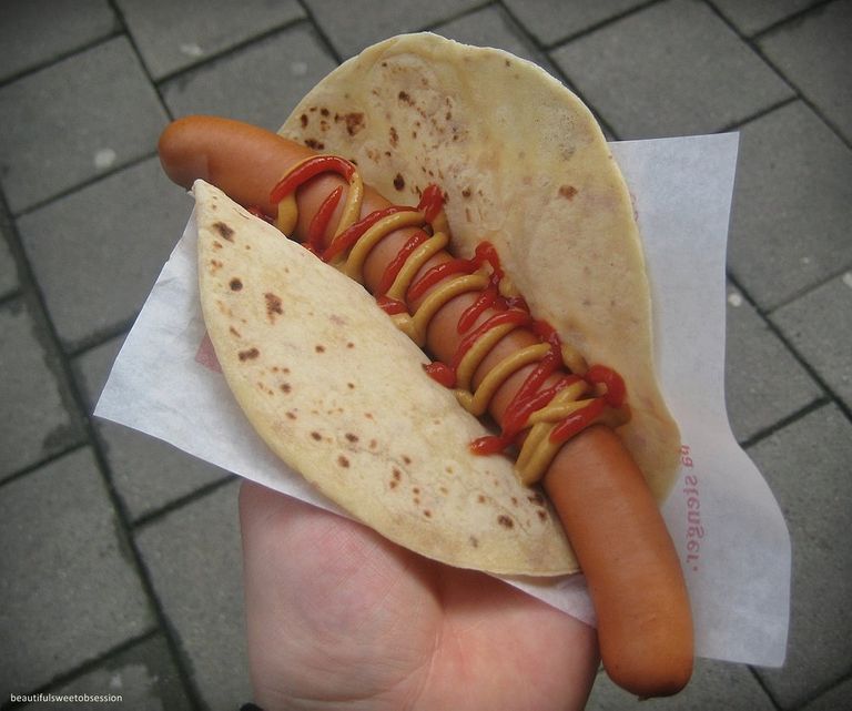 A hot dog in lompe with ketchup and mustard